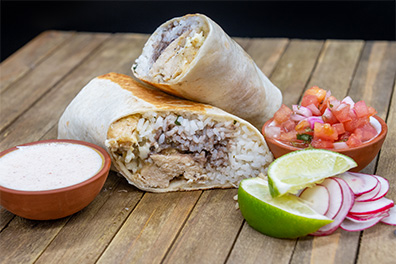 A plant-based Chicken Burrito near Woodcrest, Cherry Hill, New Jersey, sliced in half.