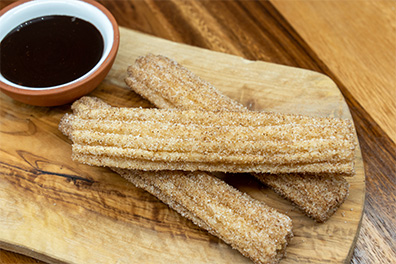 Churros with chocolate dipping sauce prepared for takeout near Barclay-Kingston, Cherry Hill, NJ.