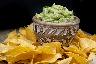 Tortilla chips and guacamole prepared for Barrington Mexican food take out.